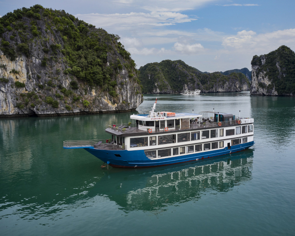Schiff in der Halong-Bucht zwischen den Kalksteinfelsen Vietnams.